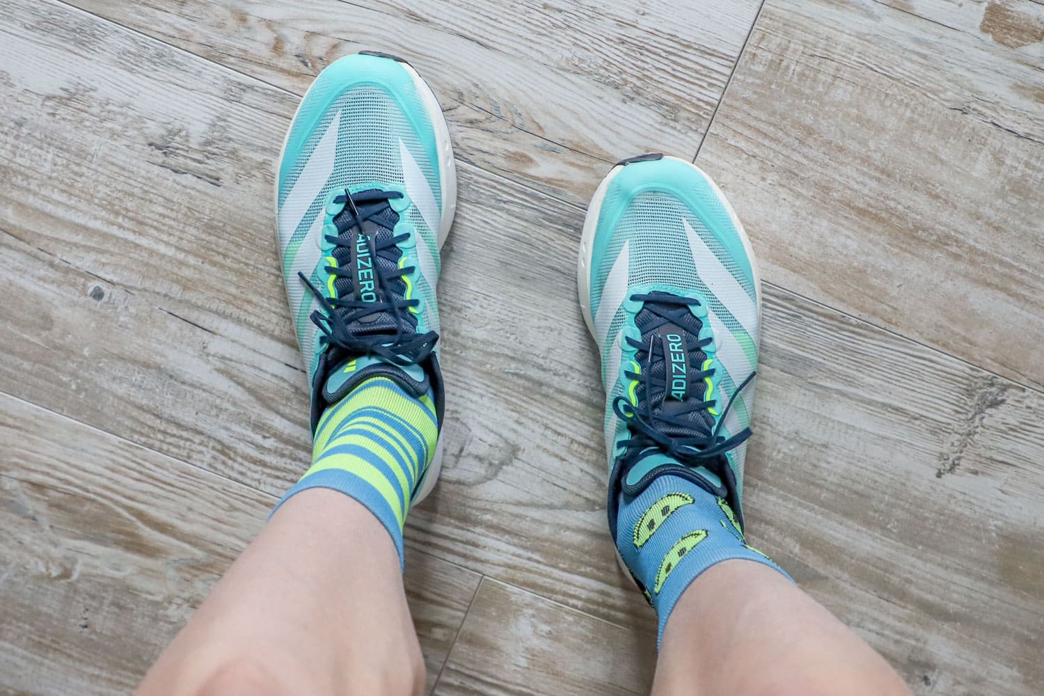 Vue plongeante sur une paire de Boston 13 montrant le laçage, la languette Adizero et le mesh aéré.