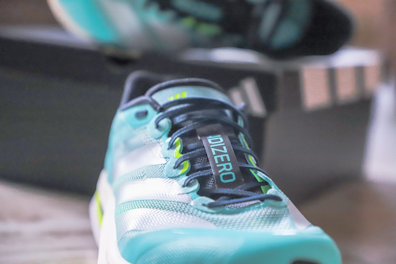 Gros plan sur le mesh technique transparent et les lacets plats de l'Adizero Boston 13.