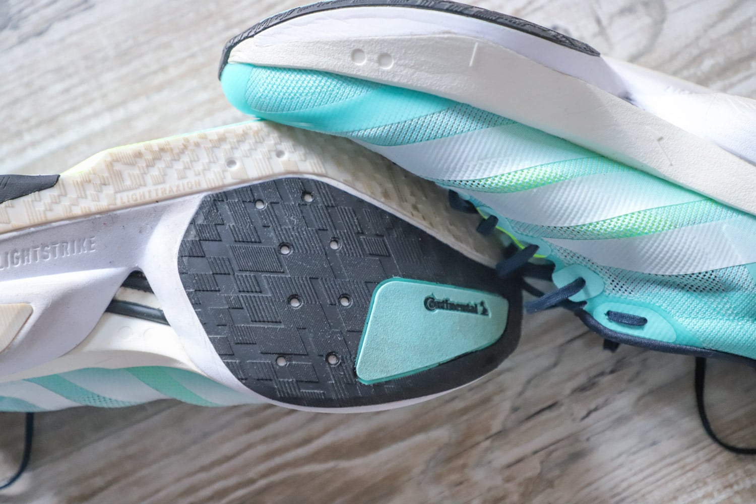 Détail de la semelle extérieure en caoutchouc Continental noir et turquoise pour une adhérence maximale.